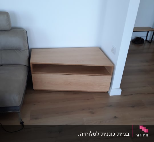שידת עץ עם מדף פתוח ליד ספה
